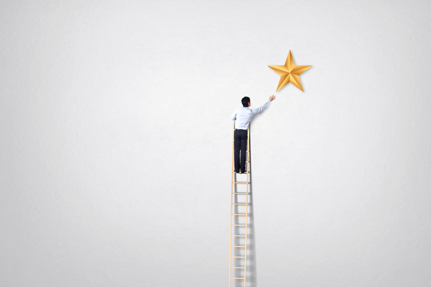 businessman climb on ladder to reach star goal